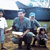 "Unknown Solldiers with Local Children - Dec 67 - Quan Loi - Mess Hall in Background"